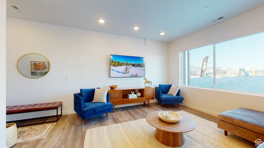 Living area with wood finished floors and recessed lighting