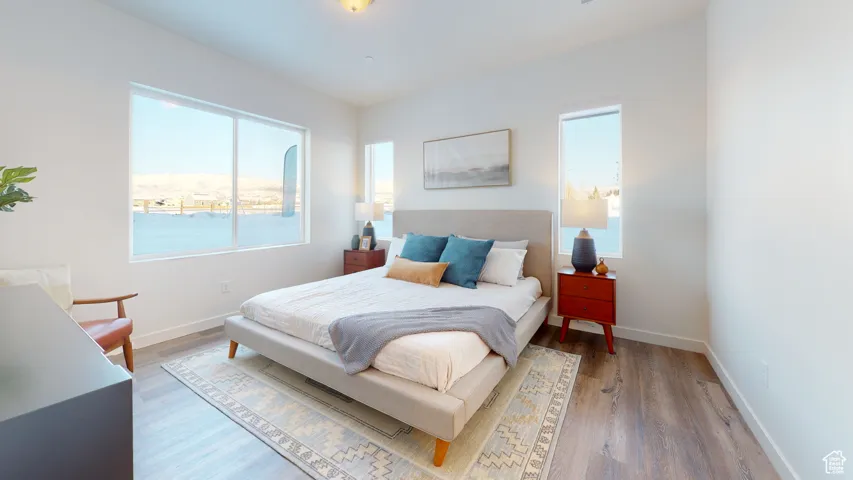 Bedroom with wood finished floors and baseboards