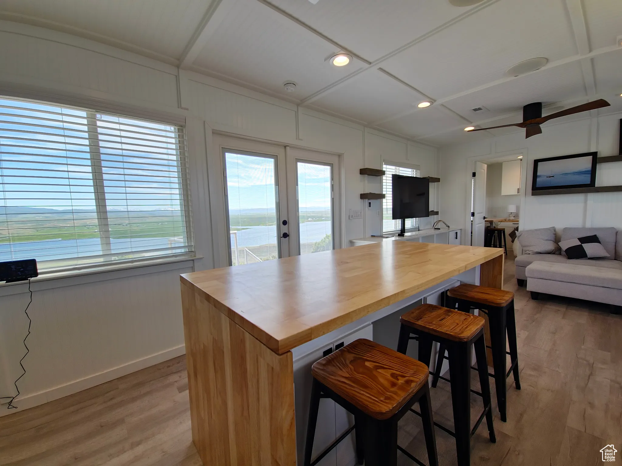 Kitchen featuring wood counters, french doors, light wood-style flooring, a ceiling fan, and open floor plan