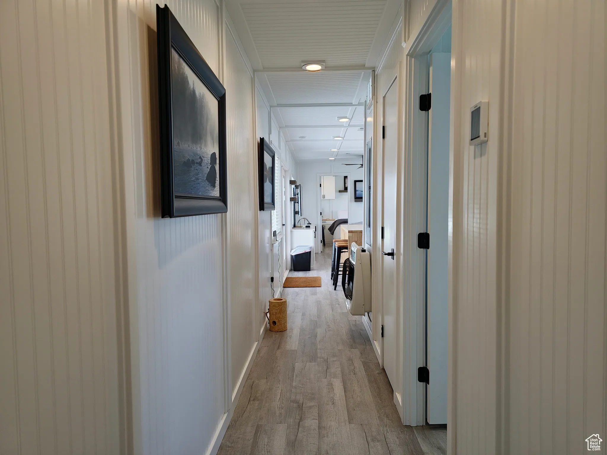 Hallway featuring wood finished floors and ornamental molding