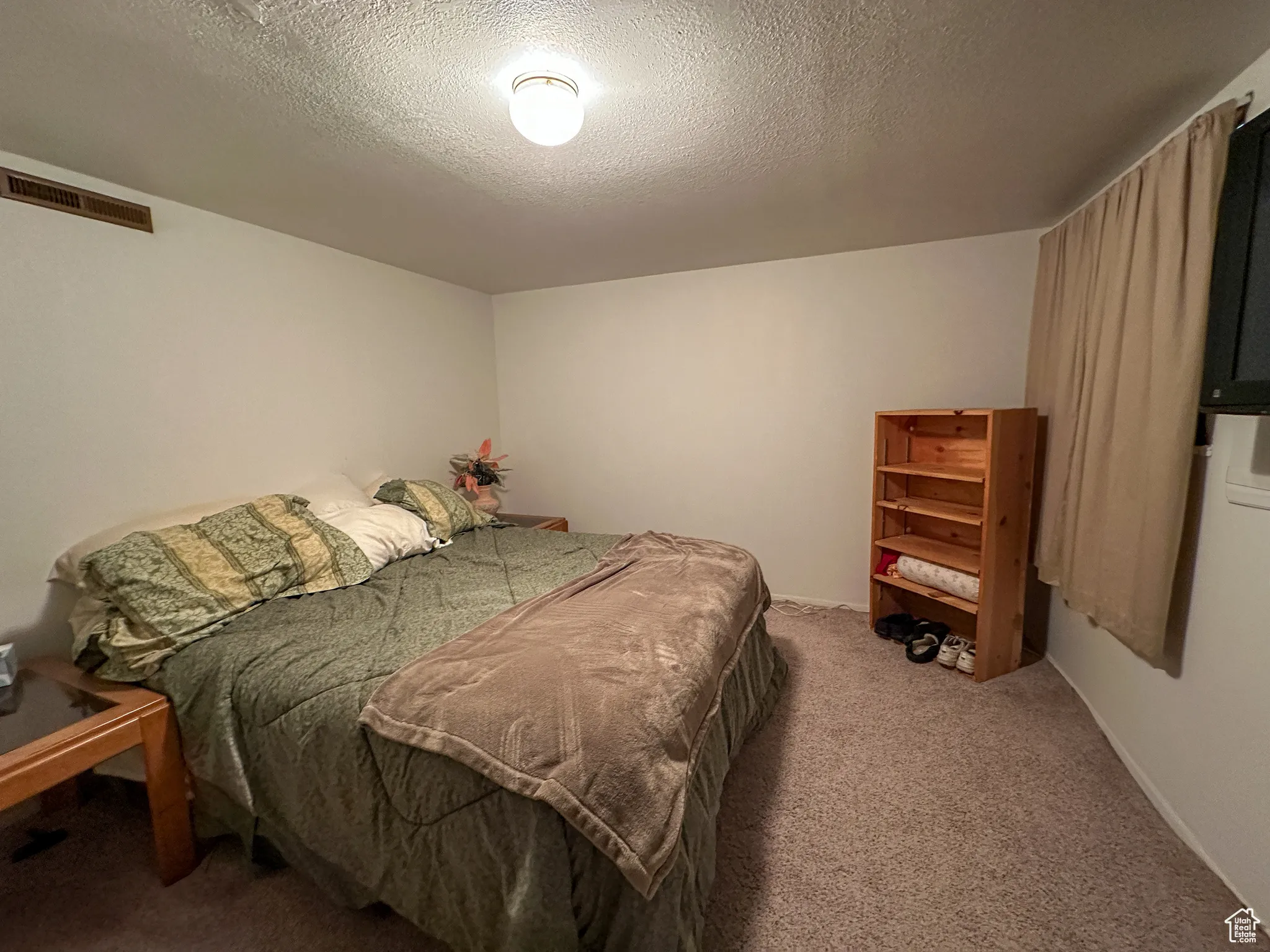 Bedroom with carpet flooring and a textured ceiling