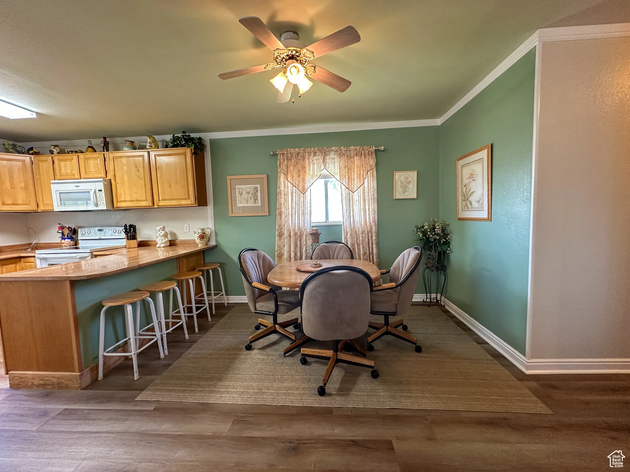 Dining room featuring ornamental molding, wood finished floors, and ceiling fan