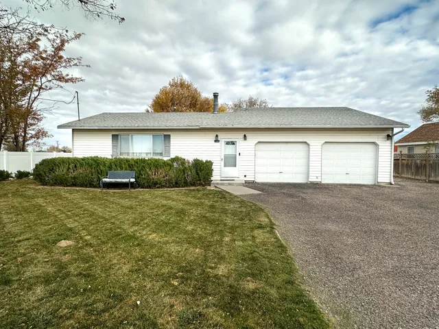 Ranch-style house featuring driveway, roof with shingles, and an attached garage