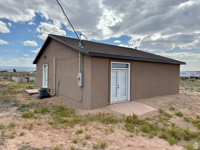 Rear view of property with roof with shingles
