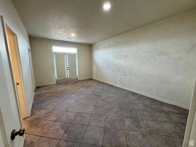 Empty room with a textured ceiling and recessed lighting