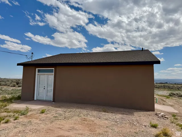View of home's exterior featuring stucco siding and roof with shingles