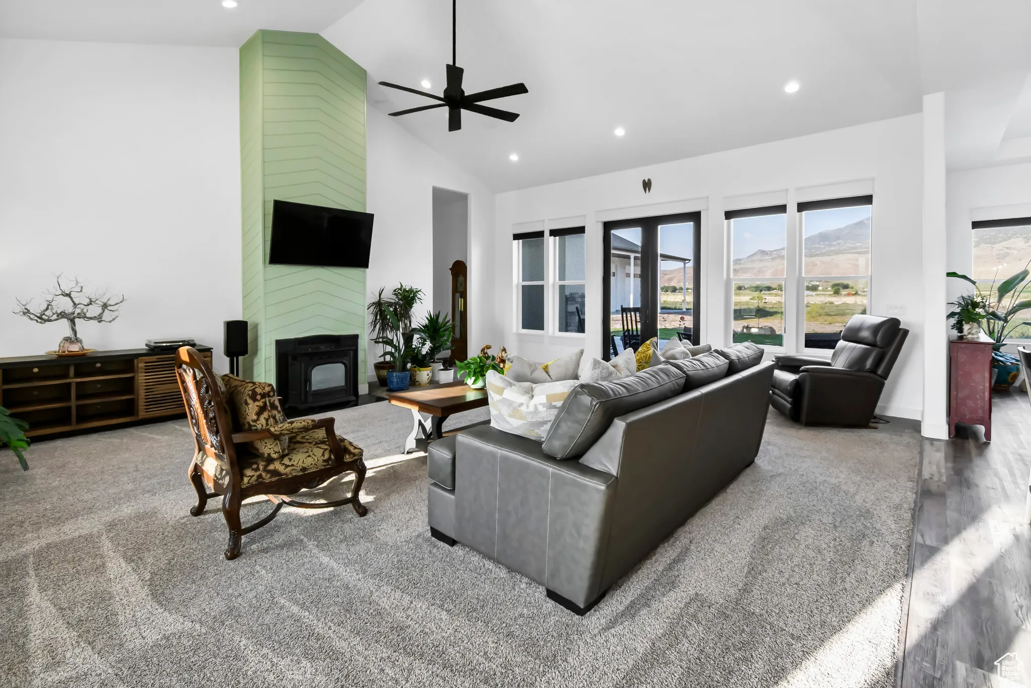 Living room featuring high vaulted ceiling, a ceiling fan, recessed lighting, a large fireplace, and carpet floors