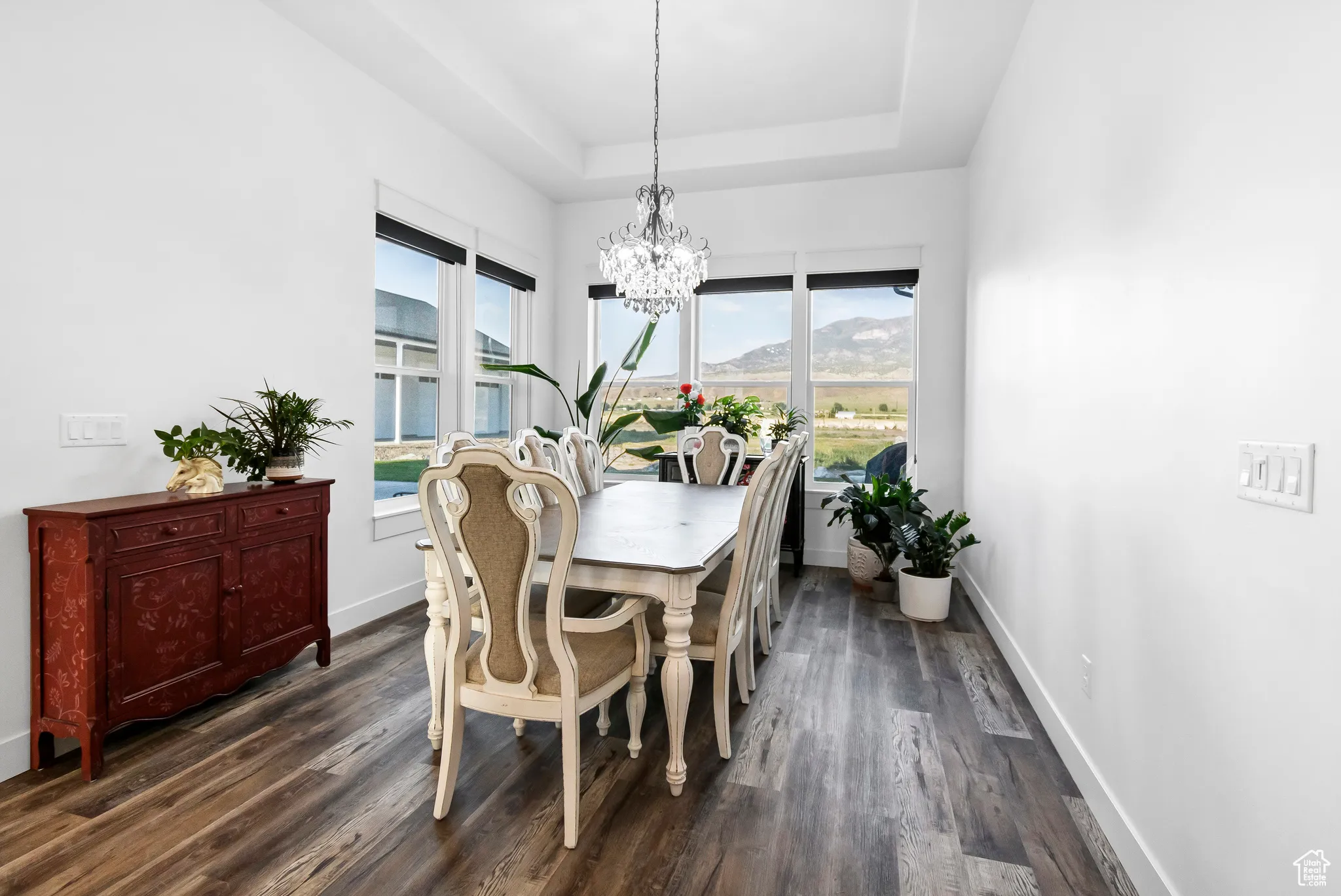 Dining space with a chandelier, plenty of natural light, and dark wood-type flooring