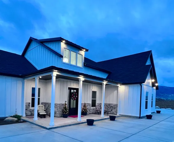 View of front of house featuring board and batten siding, a porch, a shingled roof, and stone siding