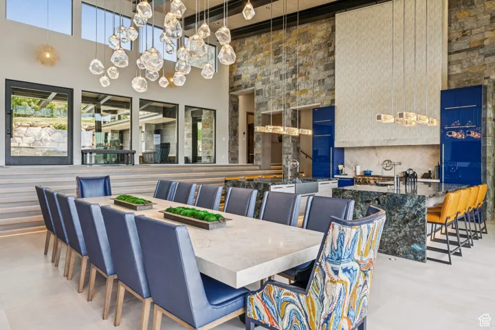Dining space featuring a towering ceiling, a chandelier, and beam ceiling