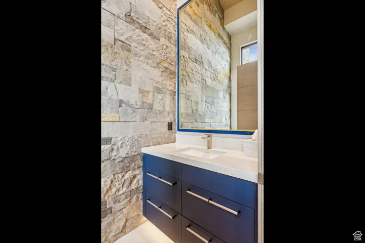 Bathroom featuring vanity and tile walls