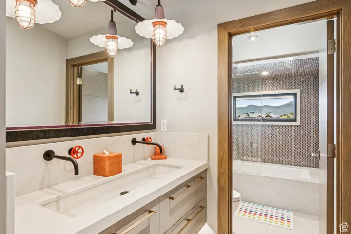 Bathroom featuring tasteful backsplash, vanity, and a tub to relax in