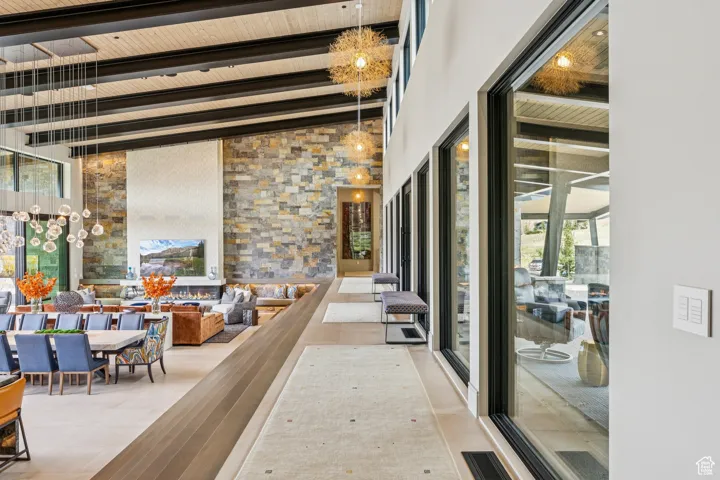 Hallway featuring beam ceiling and a high ceiling