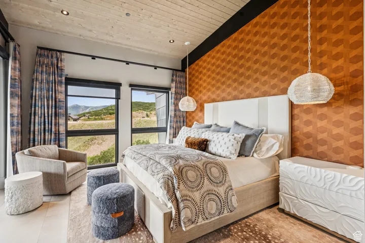 Tiled bedroom with wallpapered walls, an accent wall, recessed lighting, and wooden ceiling