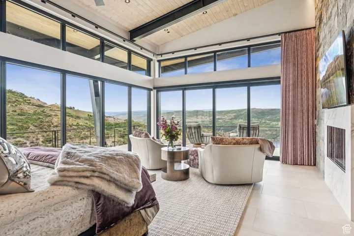 Bedroom featuring a mountain view, a wood ceiling with exposed beams, high vaulted ceiling, and tile patterned floors