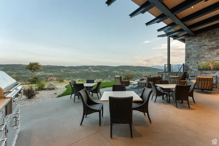 View of patio featuring outdoor dining area, a mountain view, and an outdoor kitchen