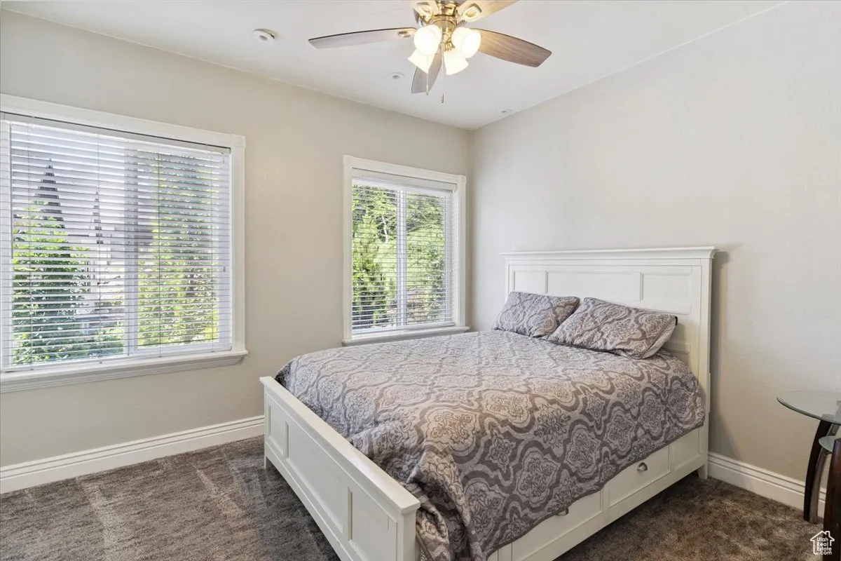 Bedroom featuring dark colored carpet and ceiling fan
