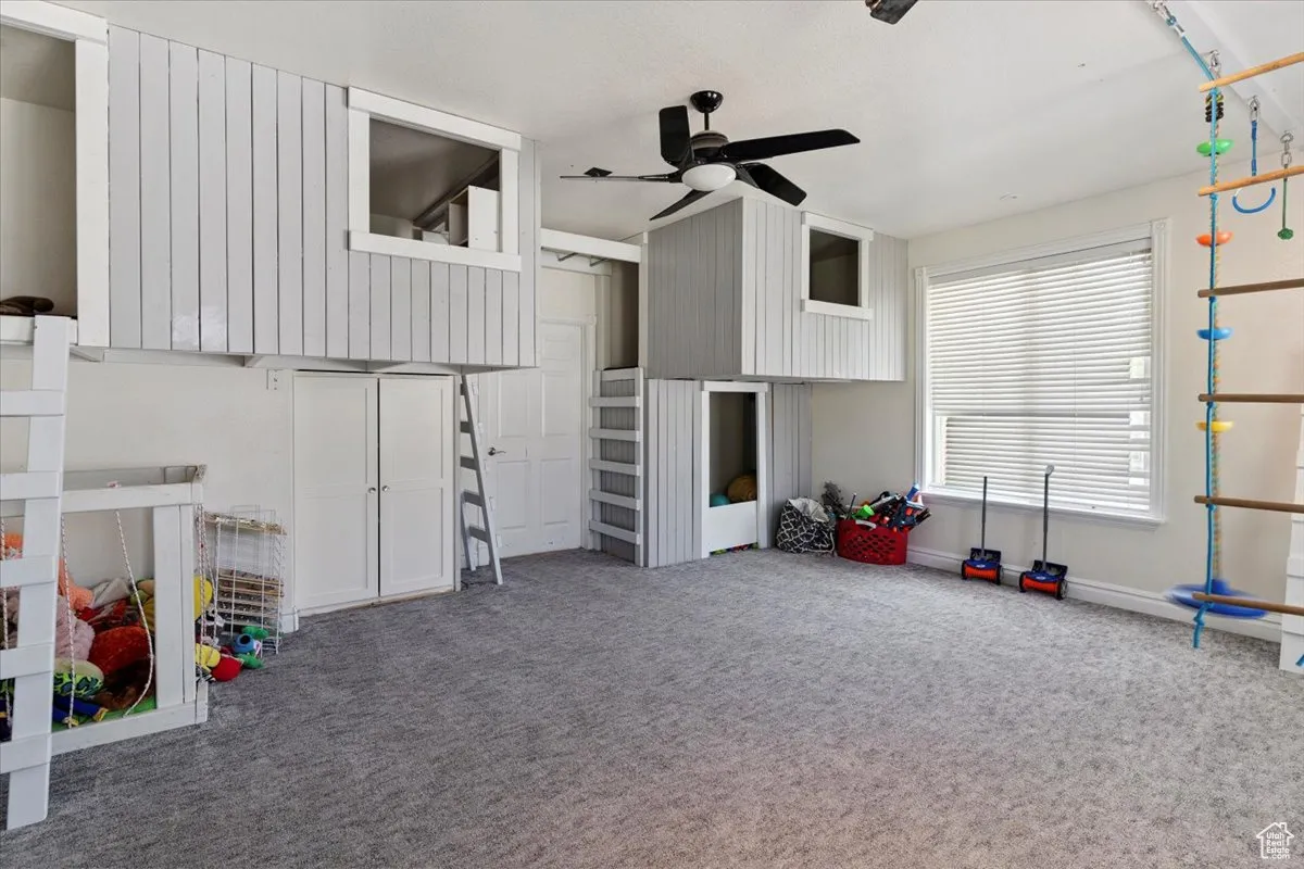 Rec room with ceiling fan and carpet