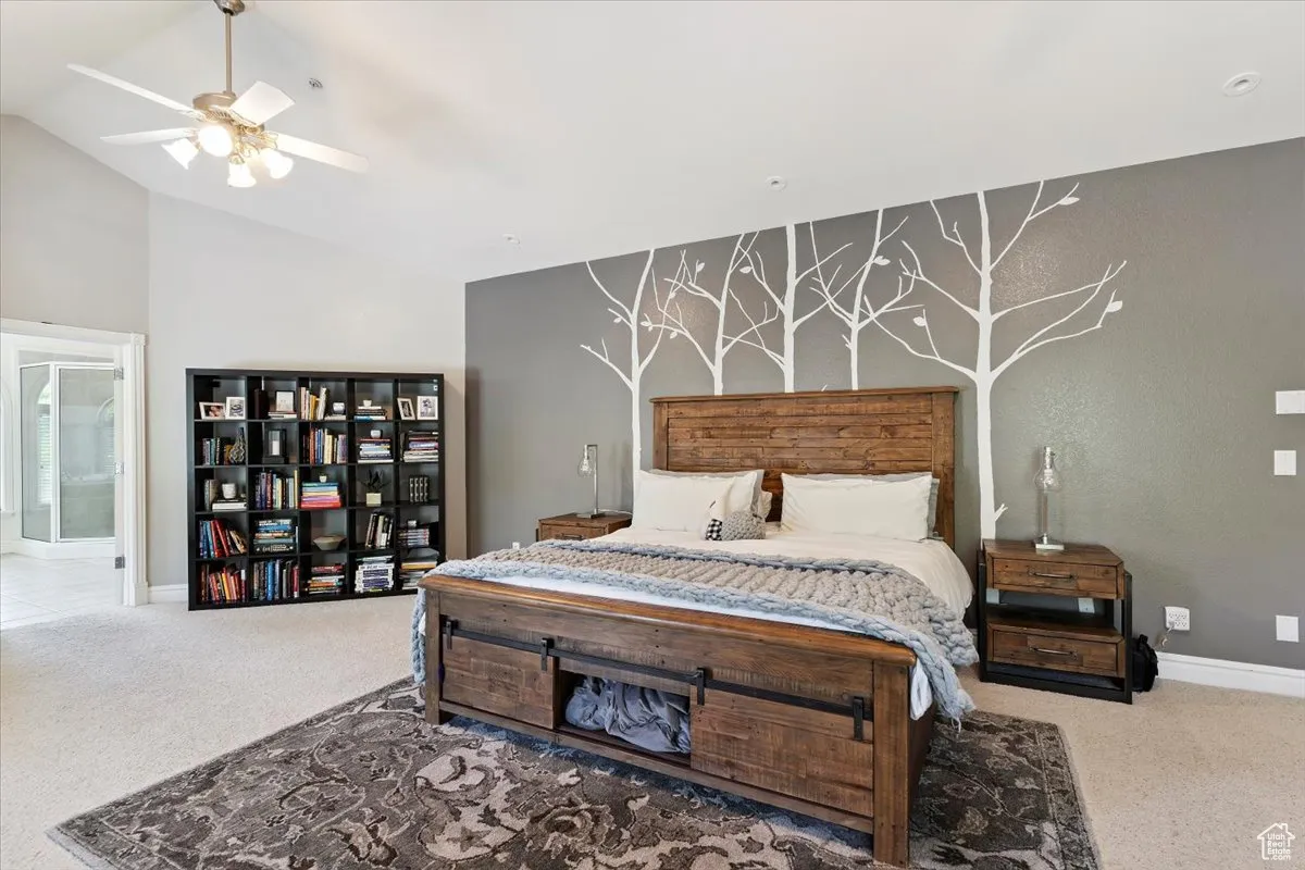Bedroom with carpet flooring, vaulted ceiling, and ceiling fan