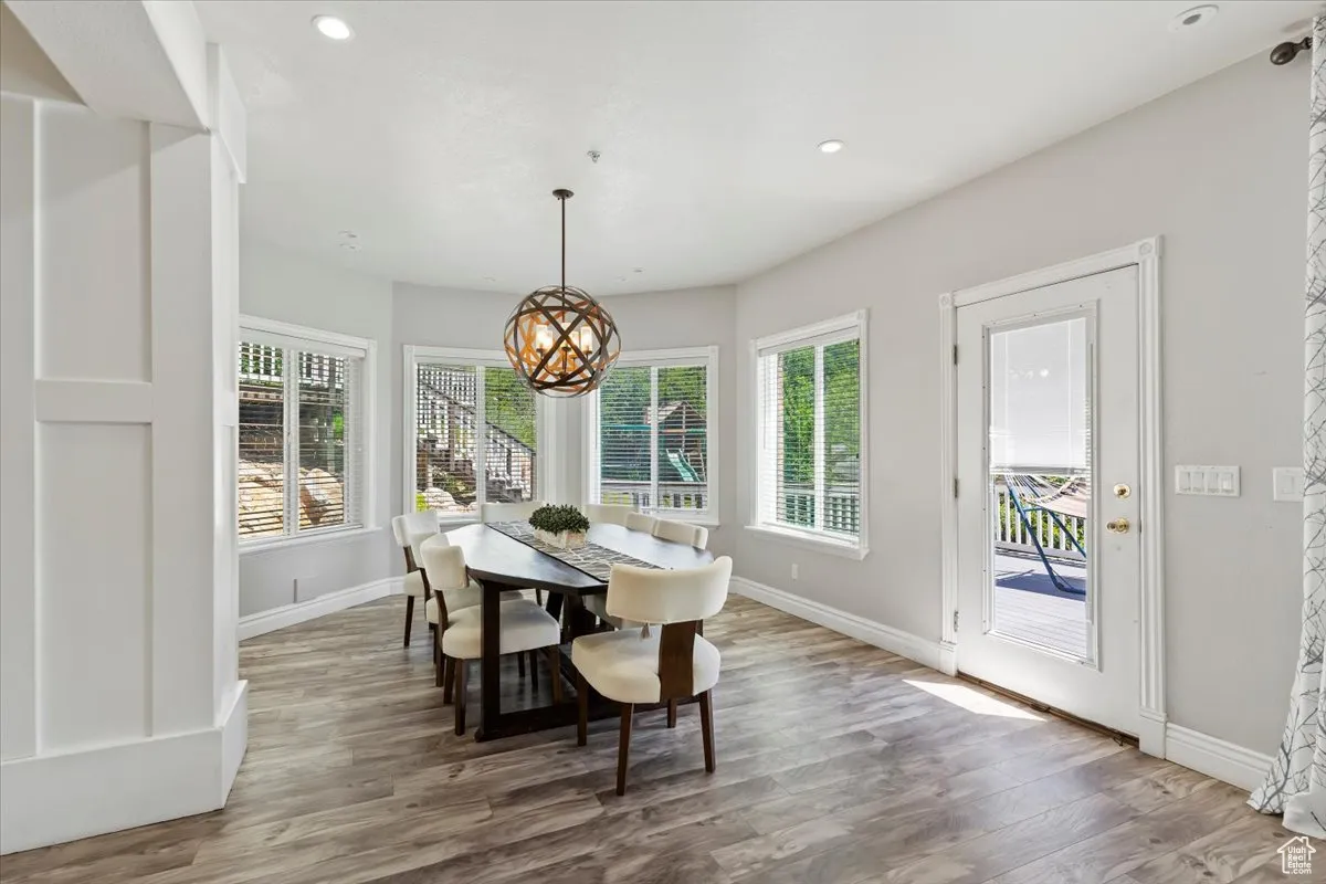 Dining space featuring a chandelier, plenty of natural light, wood finished floors, and recessed lighting