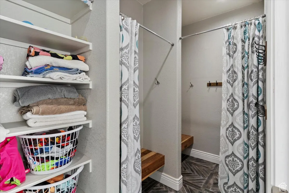 Full bath featuring a shower with curtain and baseboards