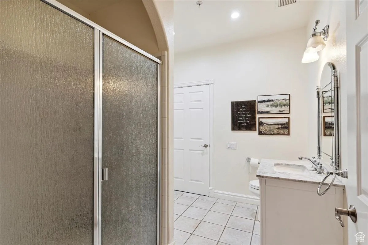 Full bath featuring tile patterned flooring, vanity, a stall shower, and recessed lighting