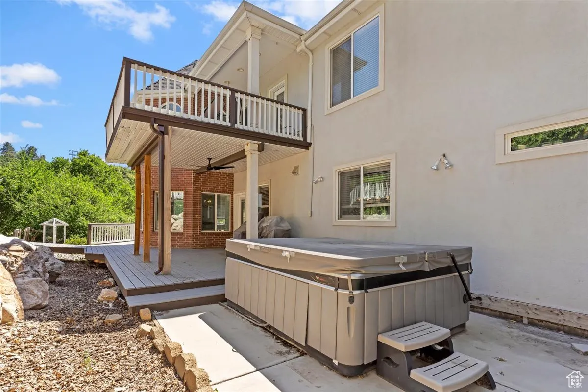 Patio / terrace featuring a hot tub, ceiling fan, a deck, and a patio