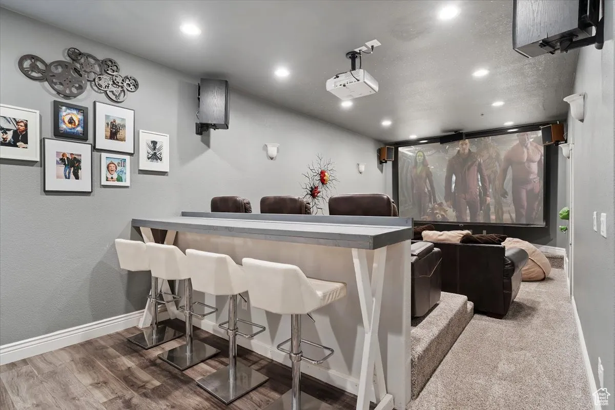 Home theater room with recessed lighting and wood finished floors