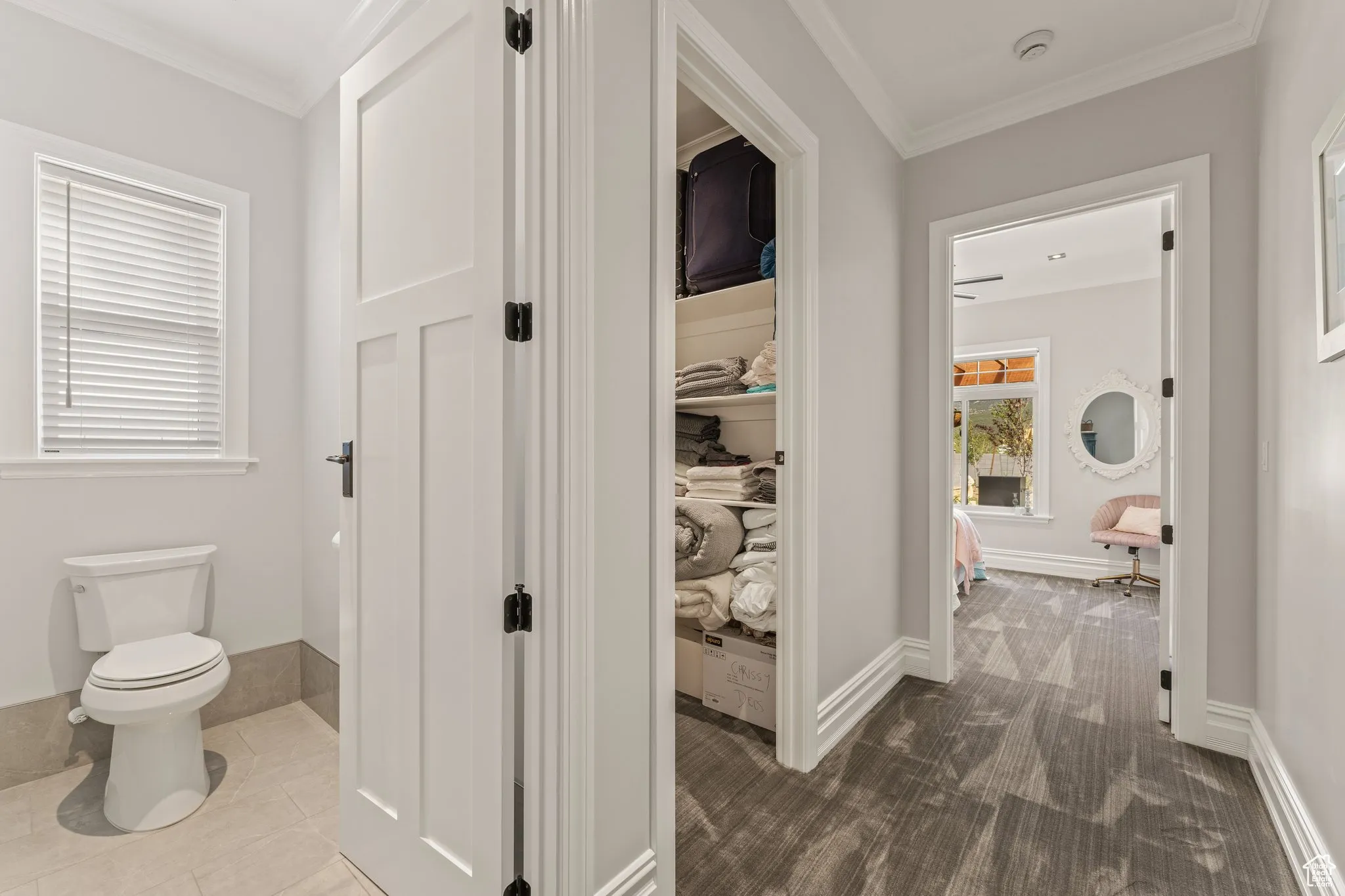 Corridor featuring crown molding and baseboards
