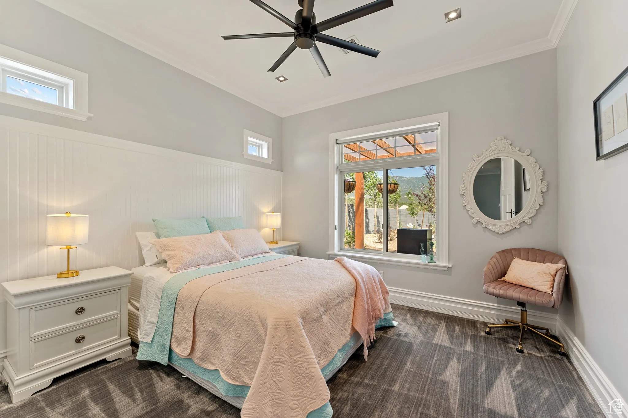 Bedroom with dark carpet, ornamental molding, and a ceiling fan
