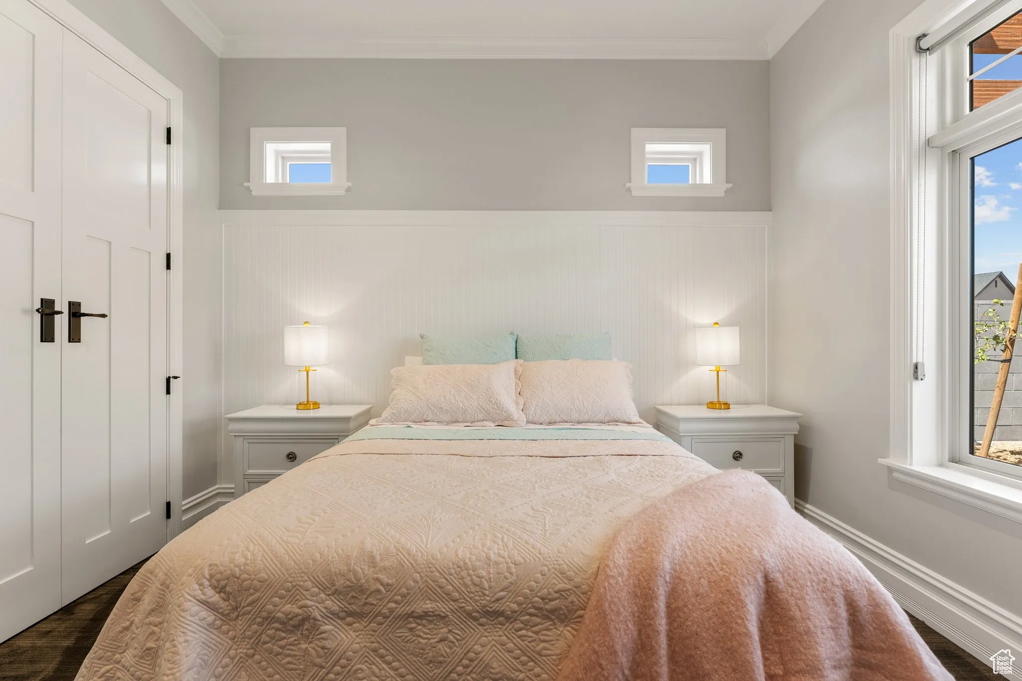 Bedroom featuring wainscoting, dark wood finished floors, and ornamental molding