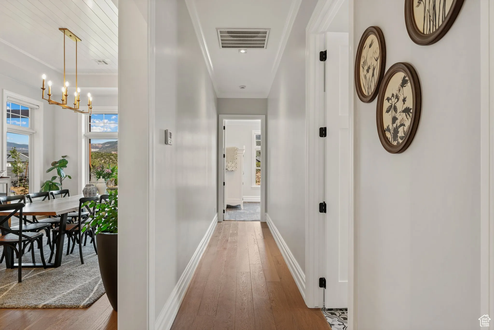 Corridor with hardwood / wood-style floors, a chandelier, and ornamental molding