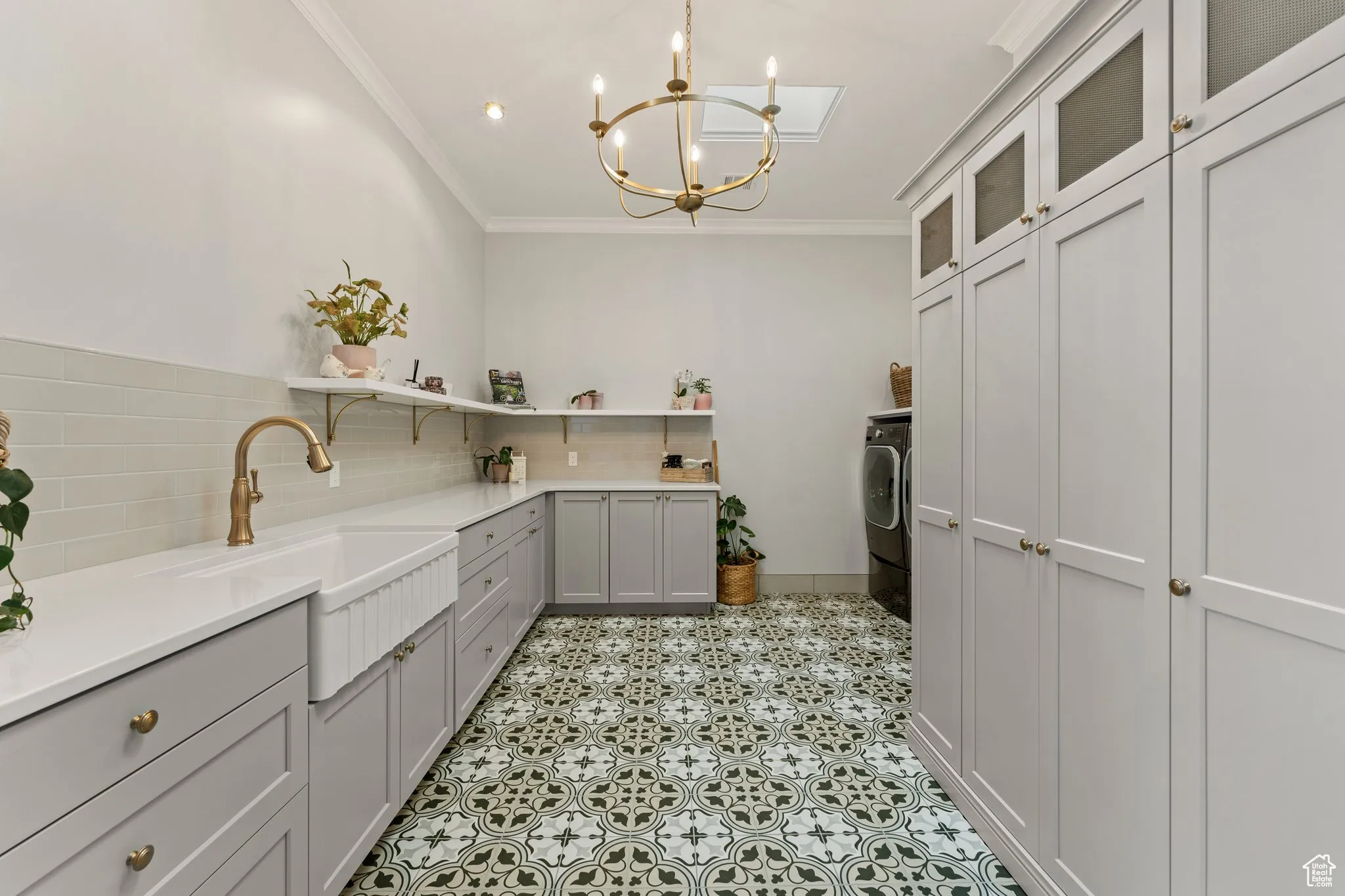 Kitchen featuring open shelves, crown molding, a chandelier, tasteful backsplash, and light countertops