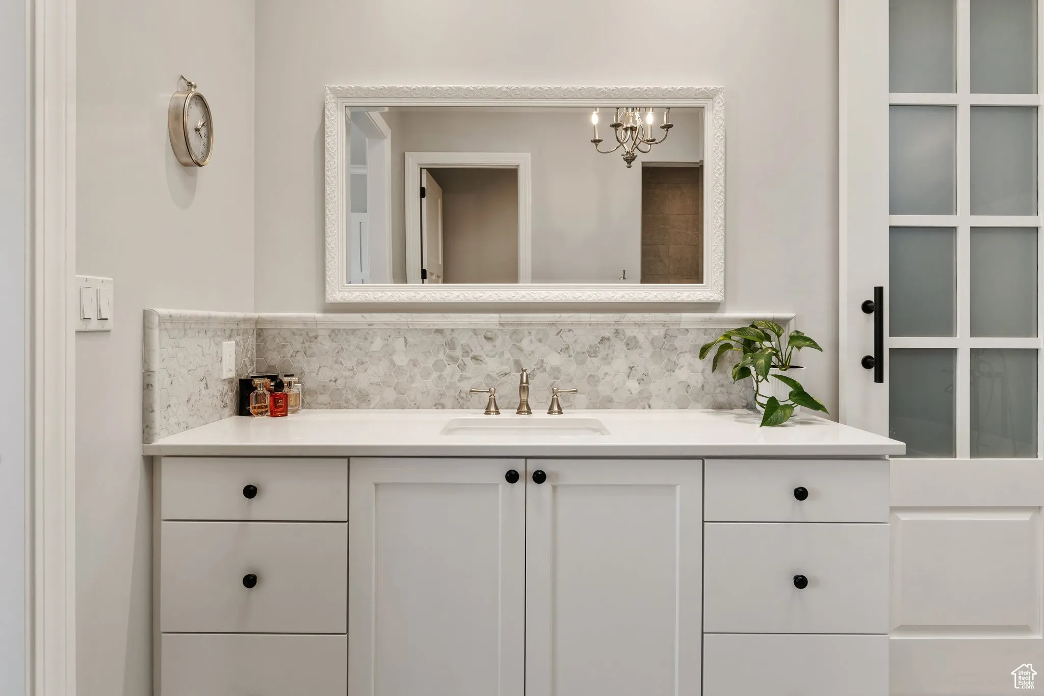 Bathroom featuring vanity, decorative backsplash, and a chandelier