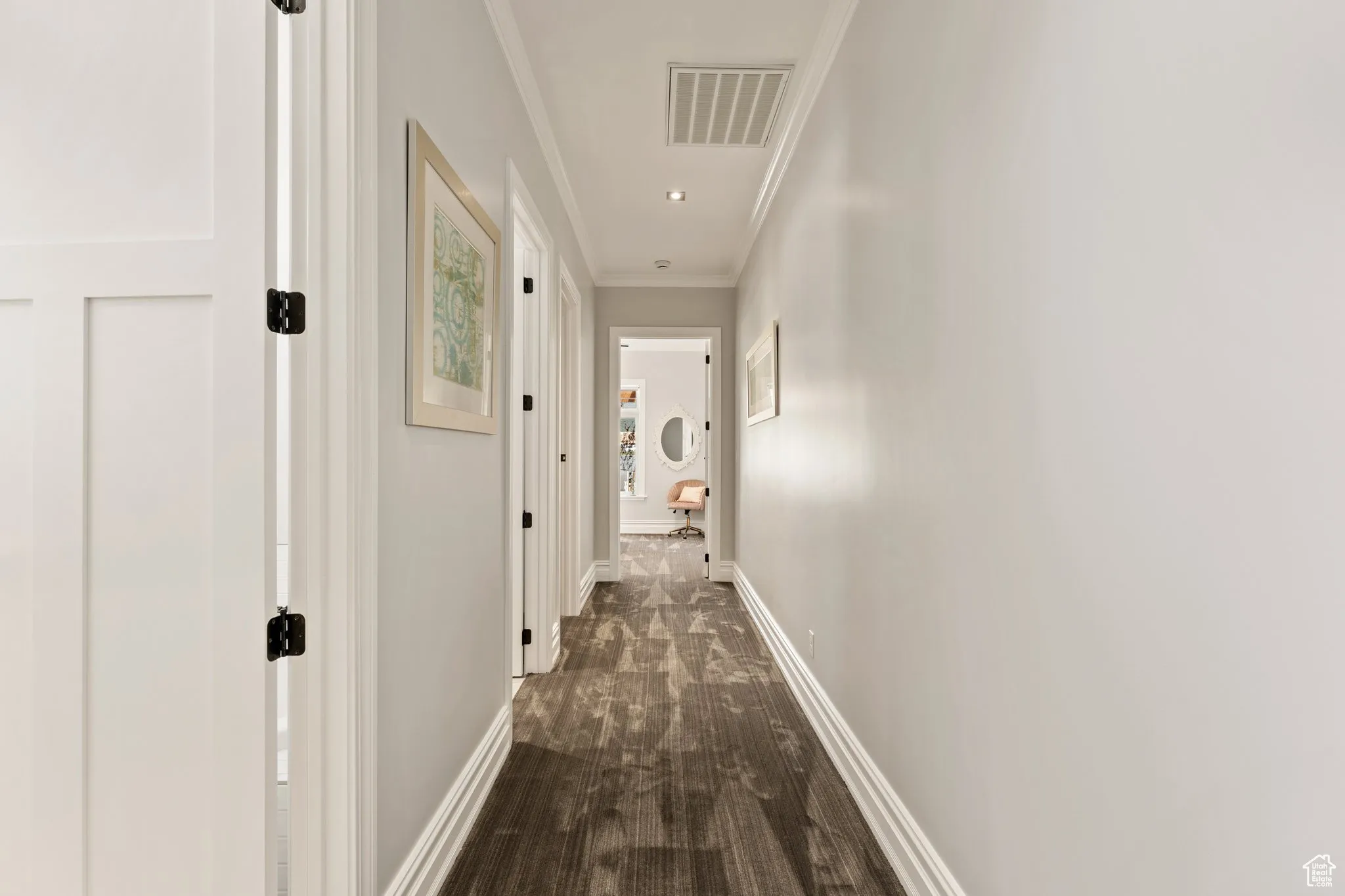 Hall with crown molding and baseboards