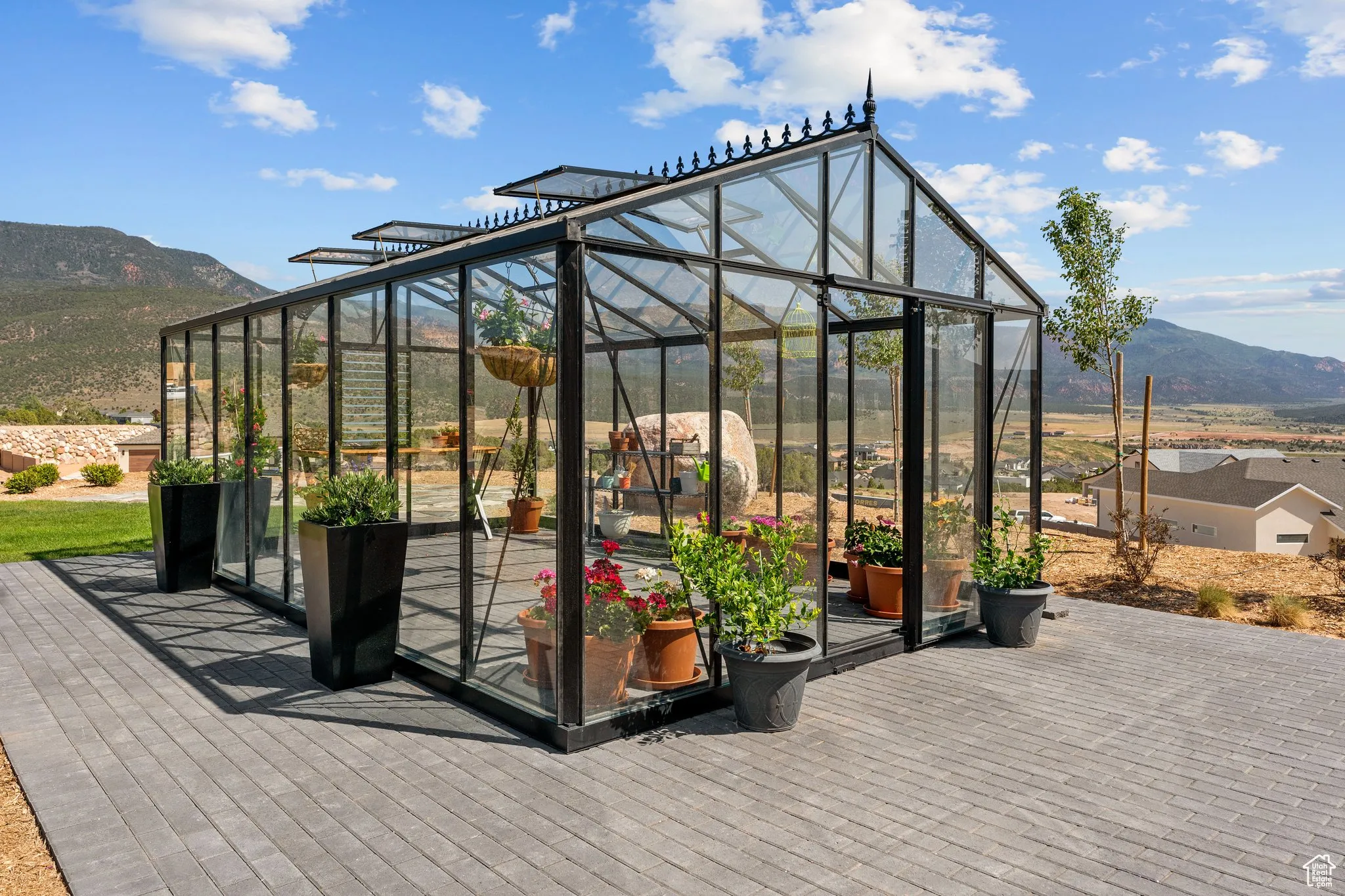 Deck with a greenhouse, a mountain view, and an outdoor structure