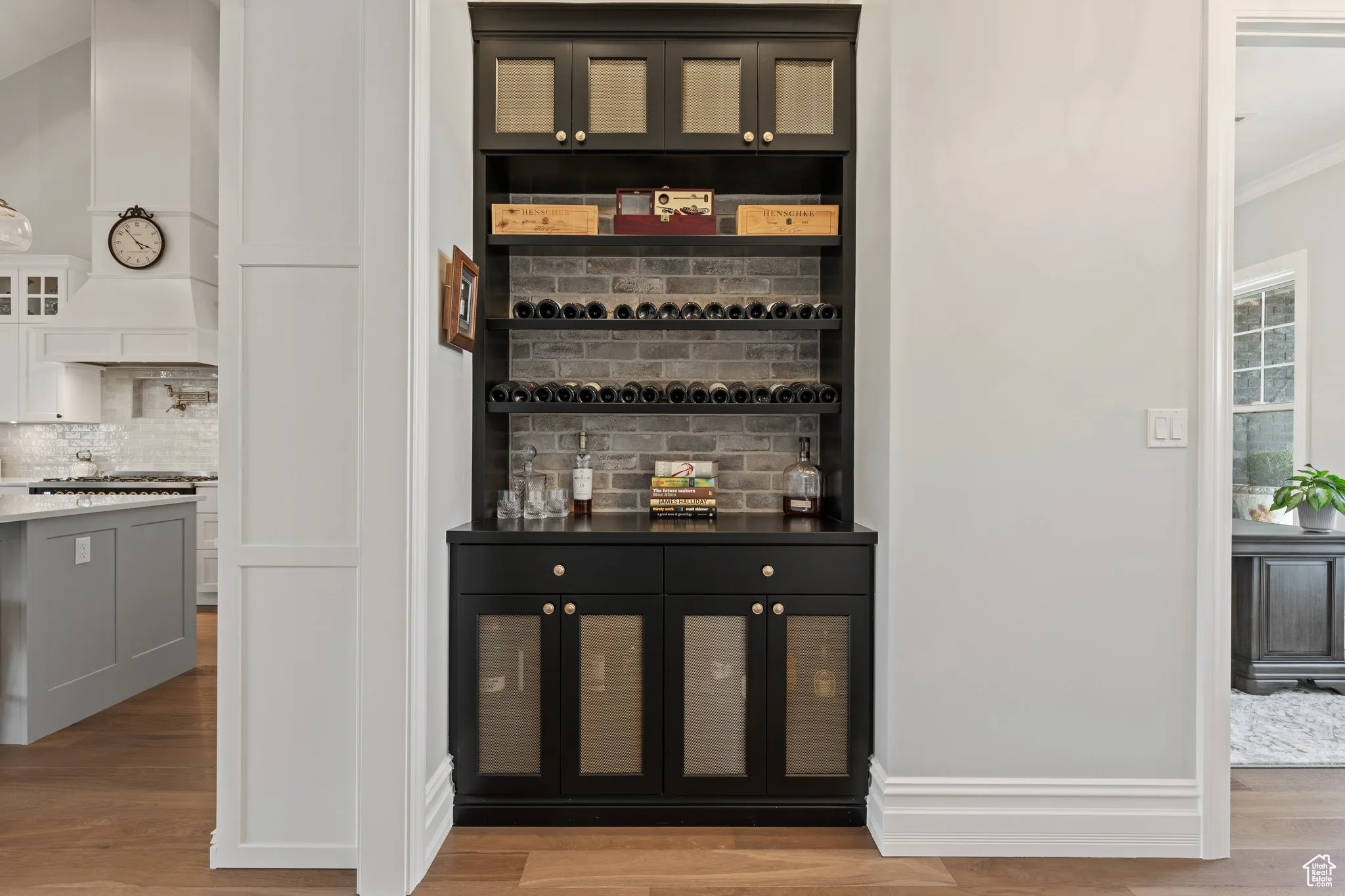 Bar featuring ornamental molding, wood finished floors, and backsplash