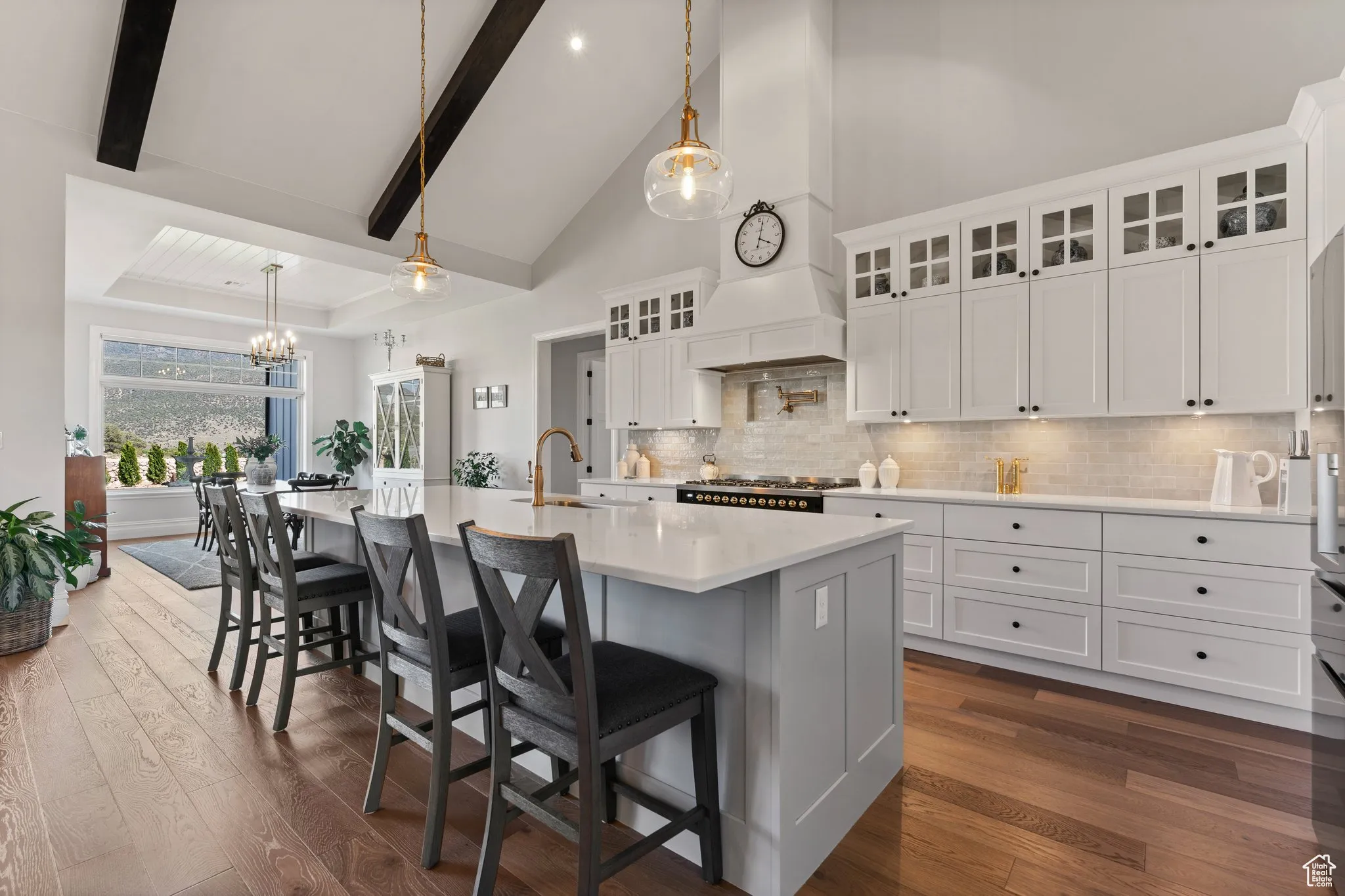 Kitchen featuring dark wood-style flooring, light countertops, decorative backsplash, a chandelier, and beamed ceiling