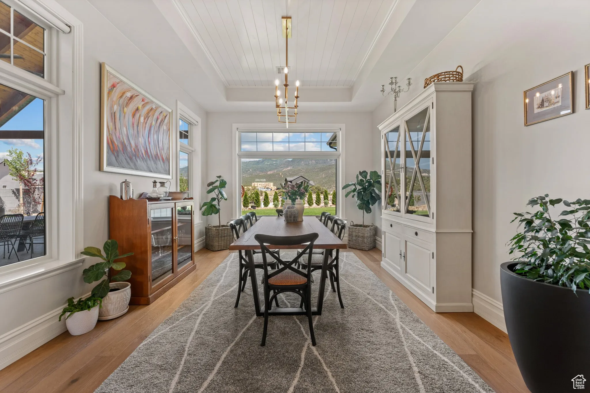 Dining room featuring a tray ceiling, a chandelier, wood finished floors, and wood ceiling