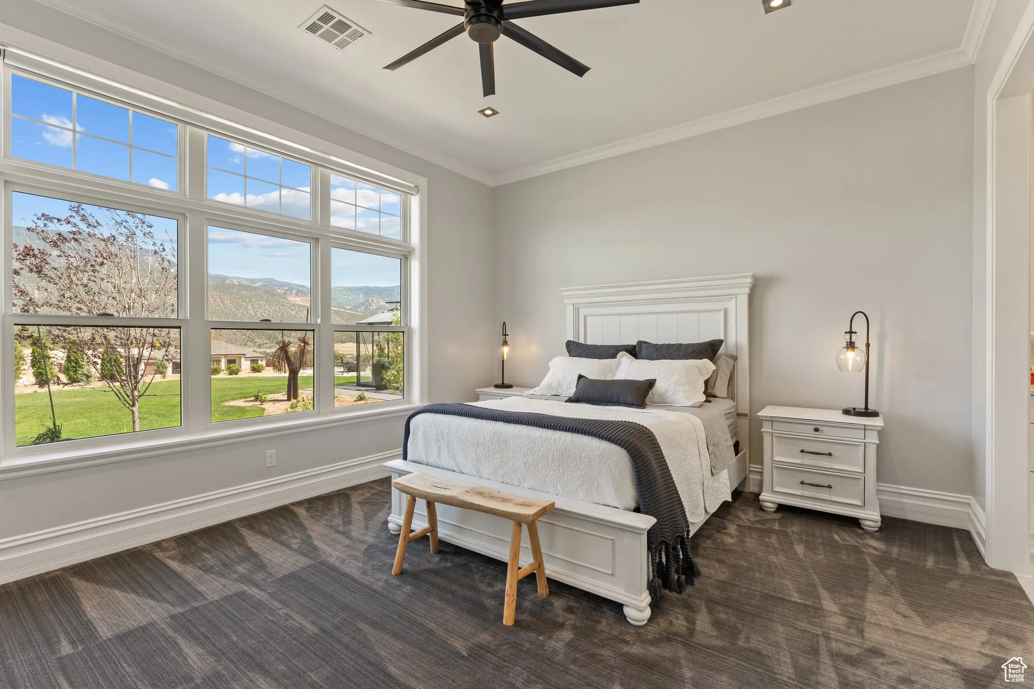 Bedroom with ornamental molding, dark colored carpet, and ceiling fan