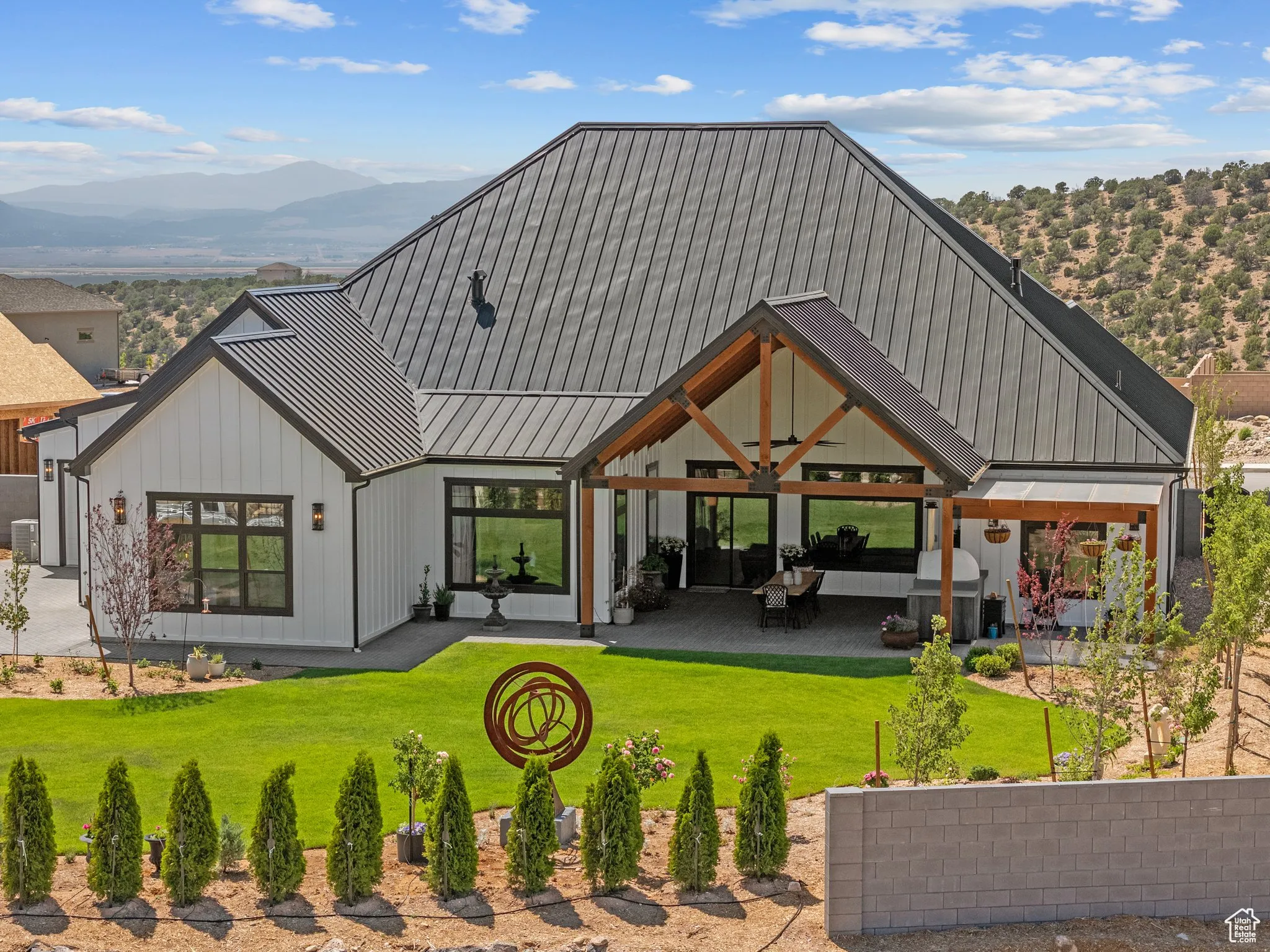 Back of property featuring a mountain view, a yard, a metal roof, board and batten siding, and a standing seam roof