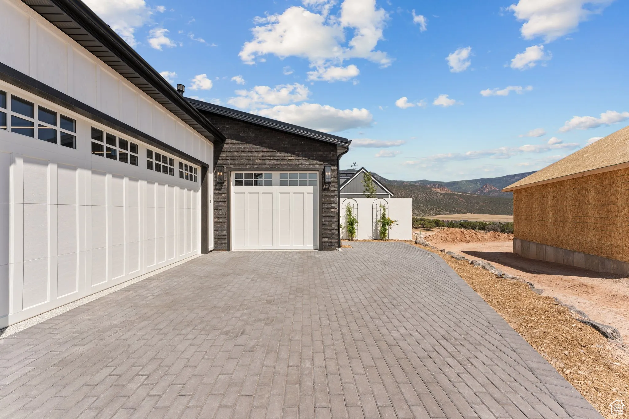 Garage with decorative driveway and a mountain view