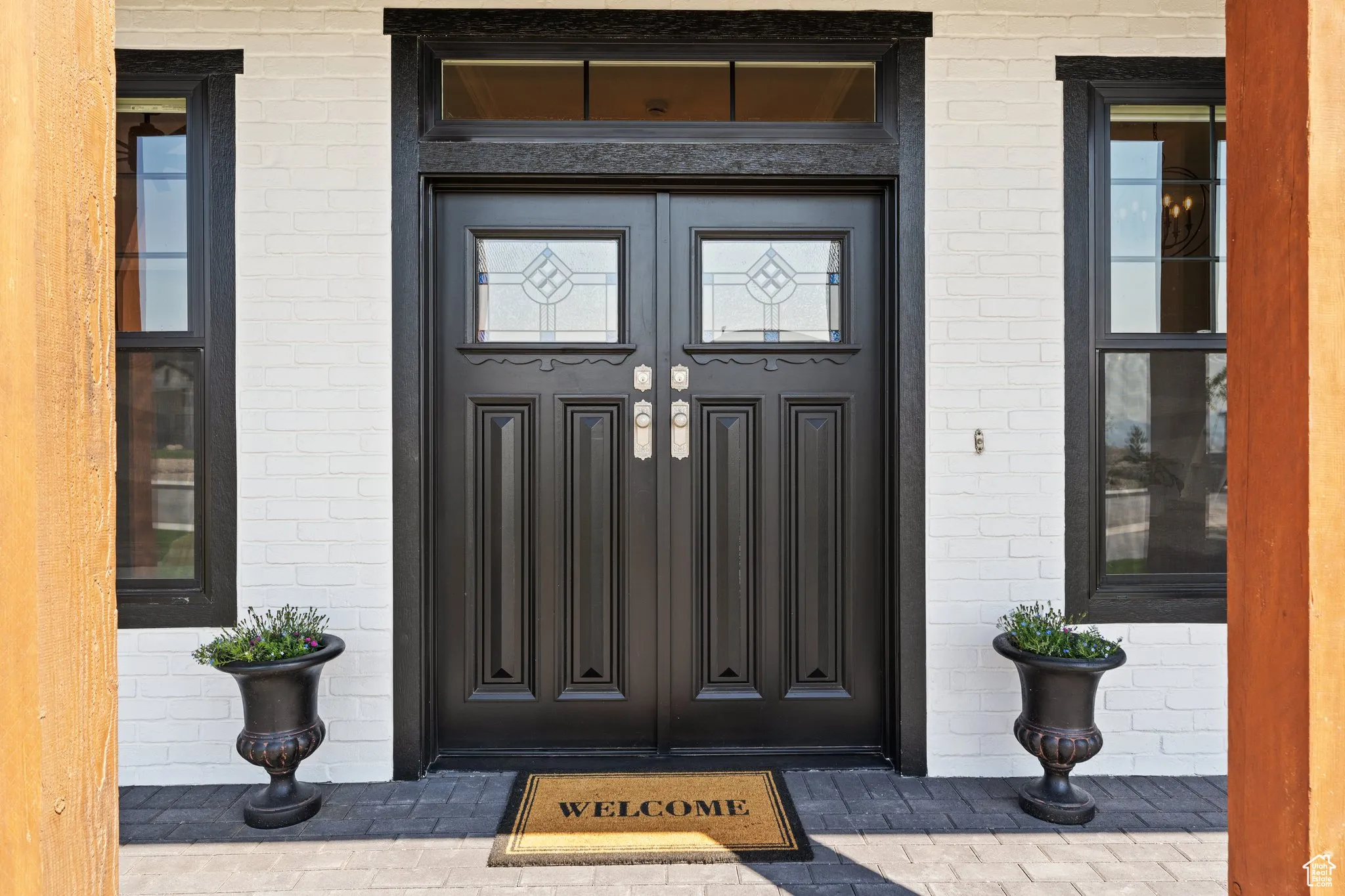Property entrance featuring brick siding and covered porch