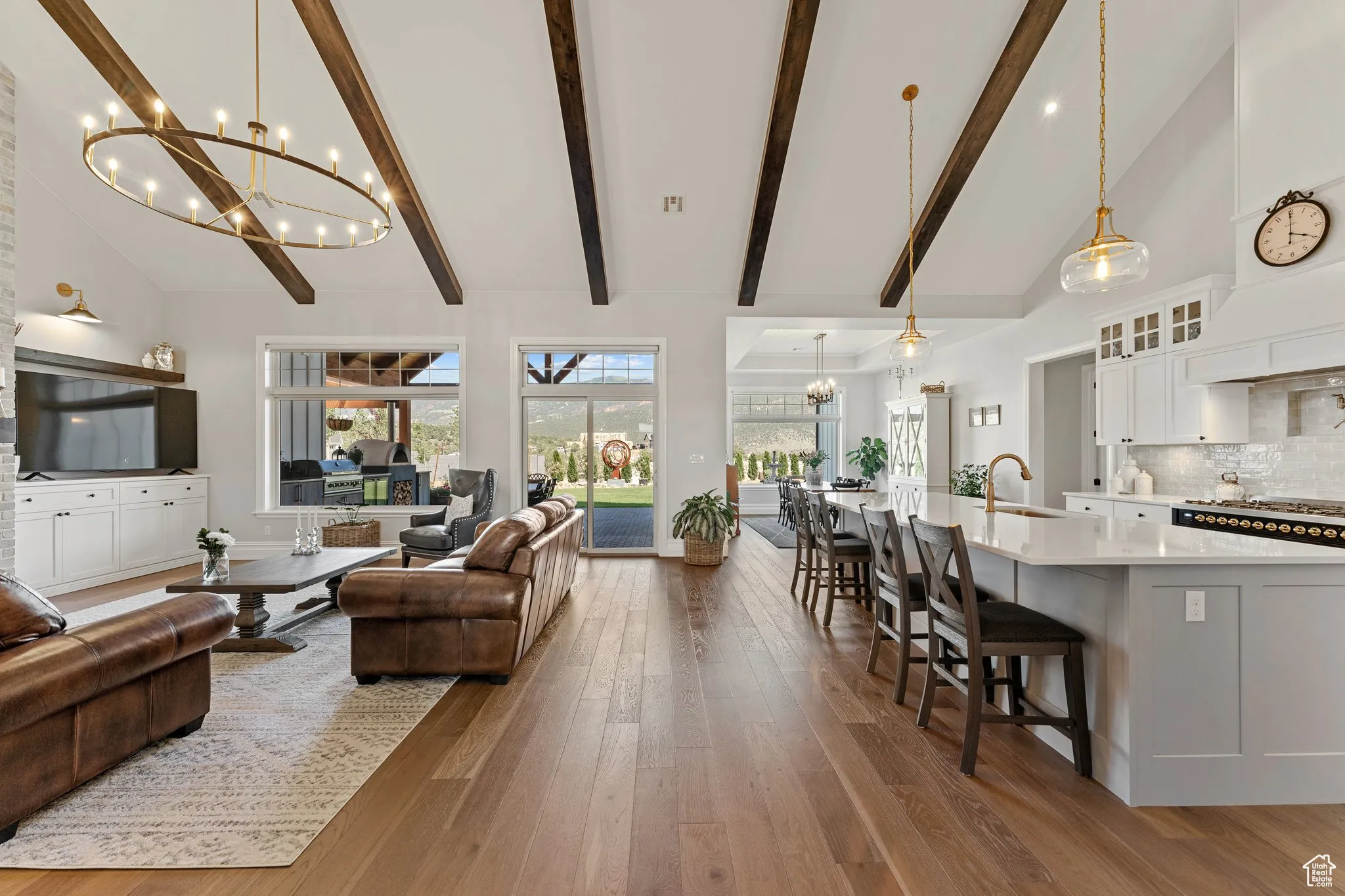 Living room featuring a chandelier, high vaulted ceiling, beam ceiling, and wood finished floors