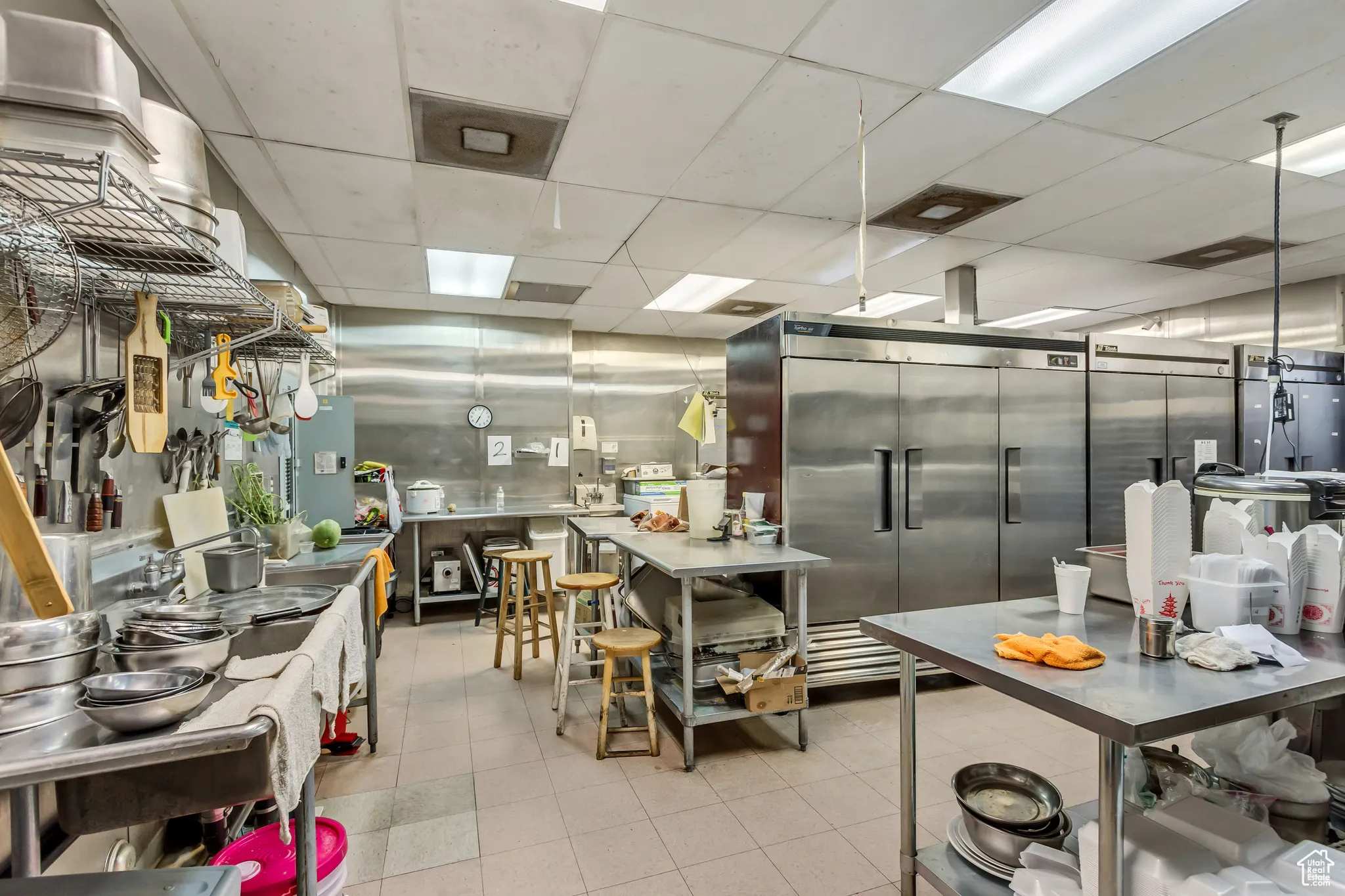 Kitchen featuring a drop ceiling, tile patterned flooring, and elevator