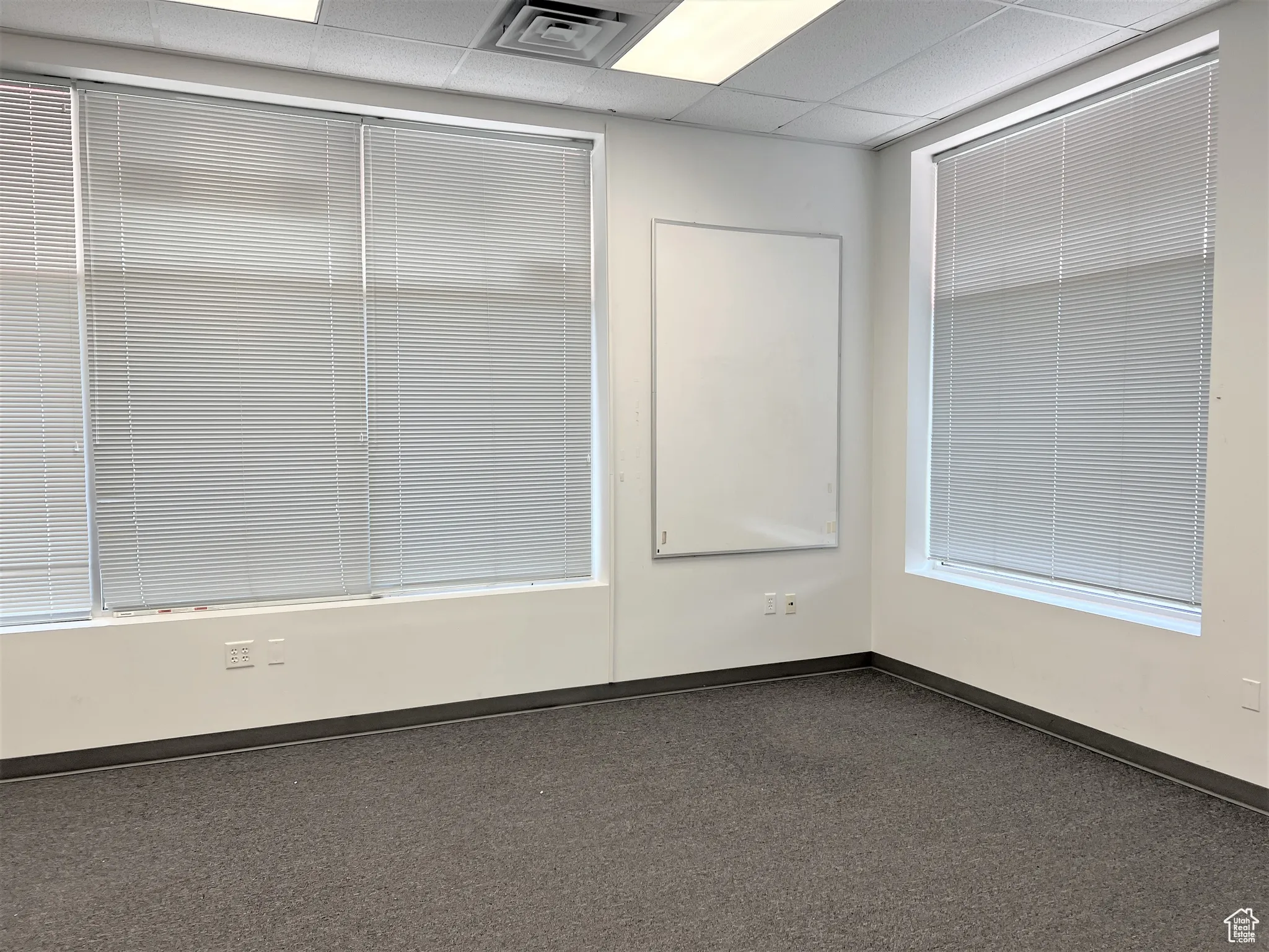 Spare room featuring a drop ceiling and baseboards