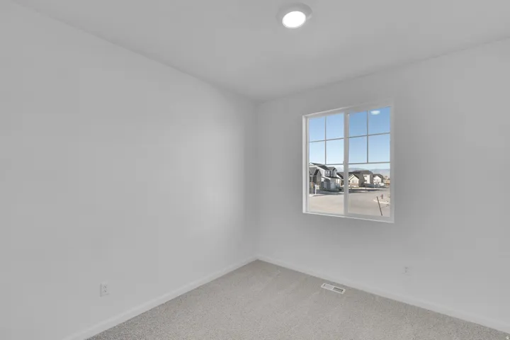 Empty room featuring carpet flooring and a residential view