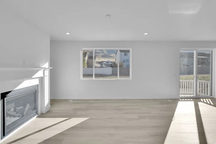 Unfurnished living room featuring light wood-style flooring, a fireplace, and recessed lighting