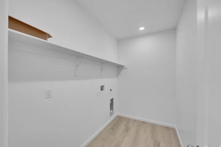 Laundry area with light wood-style floors, hookup for a washing machine, hookup for an electric dryer, and recessed lighting