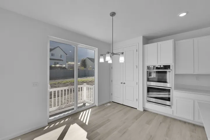 Unfurnished dining area featuring a chandelier, light wood finished floors, and recessed lighting